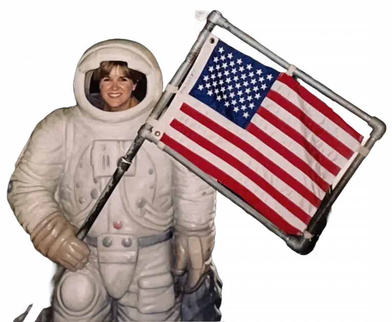 Kit in astronaut suit holding US flag