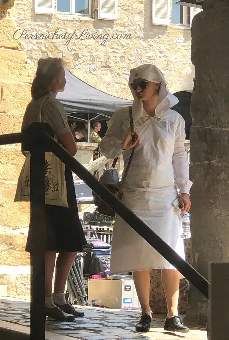 Actors in costume one a nurse taking a break from filming all the light we cannot see