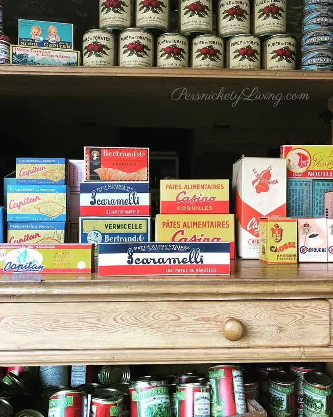 Wood shelves holding cans and boxes of french food-props for All the Light We Cannot See filmed in Villefranche de Rouergue