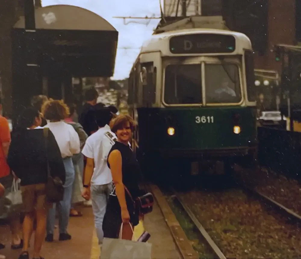 Kit standing by train tracks green train