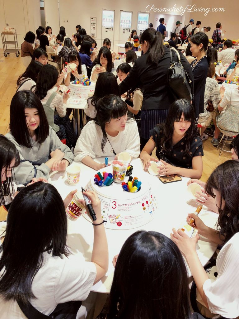 Young Japanese people at round tables Designing their own cup for noodles