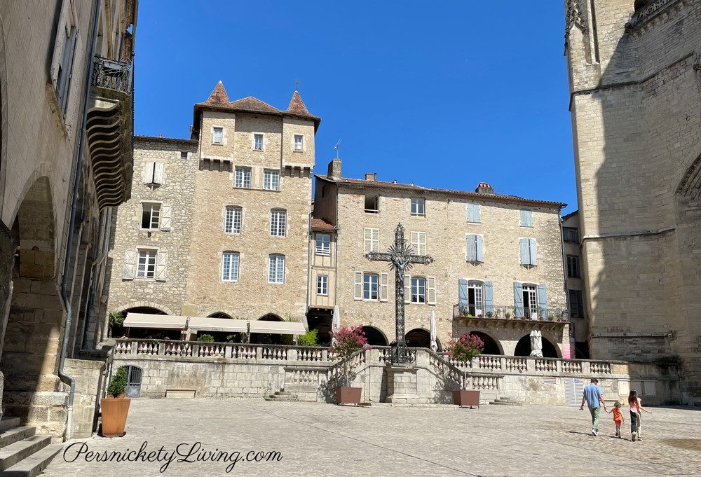Place Notre Dame in Villefranche de Rouergue France with Medieval buildings family walking towards the cathedral