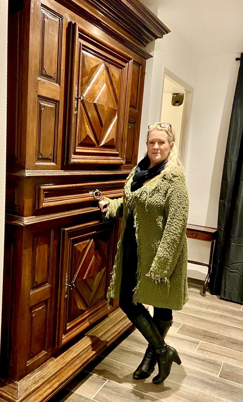 Kit standing next to a very large armoire bought second hand