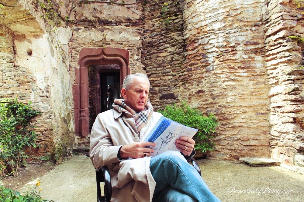 My husband reading about the castle in French town Belcastel